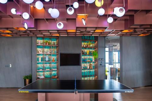 una mesa de ping pong en medio de una habitación en 芭提雅Edge极致高端景观房-海景城景巨大顶楼泳池-健身房按摩房乒乓球室花园餐厅, en Pattaya central