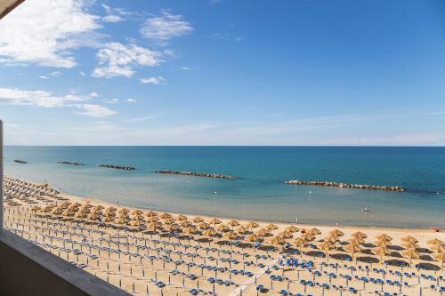 a view of a beach with umbrellas and the ocean at Hotel Mara in Ortona