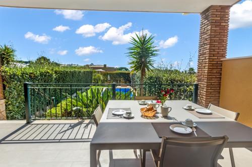 a patio with two tables and chairs on a balcony at Vale de Milho Village in Carvoeiro