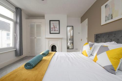 een grote witte slaapkamer met een groot bed met kussens bij Chill in Gill Comfy House, Free Parking x 1 in Gillingham