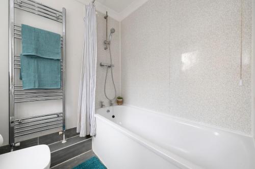 een witte badkamer met een bad en een toilet bij Chill in Gill Comfy House, Free Parking x 1 in Gillingham