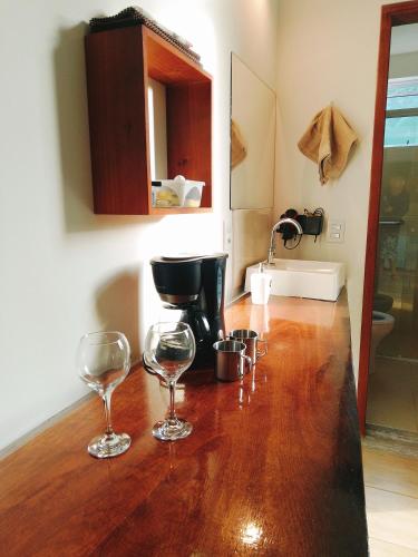 two wine glasses sitting on top of a wooden counter at Green Lodge in Florianópolis