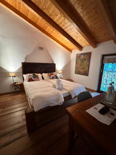 a bedroom with a large bed in a room with wooden ceilings at Maso Sasso - La Locanda di Putipù in Villa Lagarina