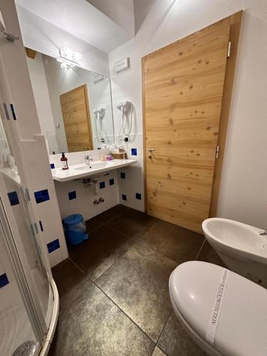 a bathroom with a sink and a toilet and a mirror at Maso Sasso - La Locanda di Putipù in Villa Lagarina