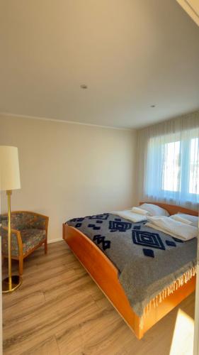 a bedroom with a large bed and a chair at MILITARY Guest Inn in Drawsko Pomorskie