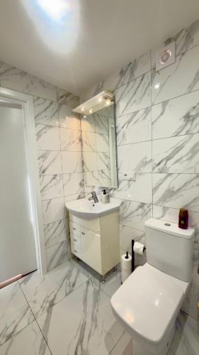 a white bathroom with a toilet and a sink at MILITARY Guest Inn in Drawsko Pomorskie