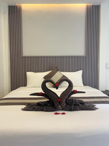 two black swans arerendered to look like they are laying on a bed at Prukrom Lanta Guesthouse in Ko Lanta