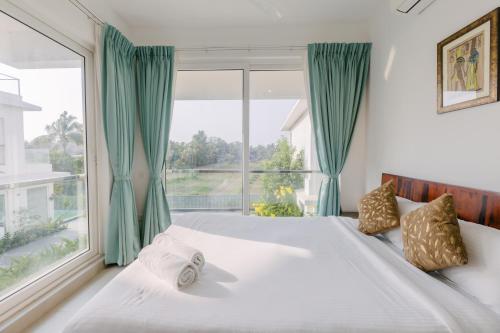ein Schlafzimmer mit einem Bett mit einem großen Fenster in der Unterkunft Humble Pineapple by Da Alohas in Calangute