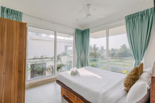 ein Schlafzimmer mit einem Bett und einem großen Fenster in der Unterkunft Humble Pineapple by Da Alohas in Calangute