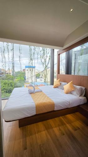 a large bed in a room with a large window at Hotel Amigos in Bangalore