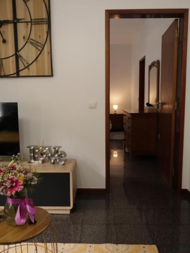 a room with a table and a clock on the wall at Retiro encantador em Machico - 5 min Praia e Centro A in Machico