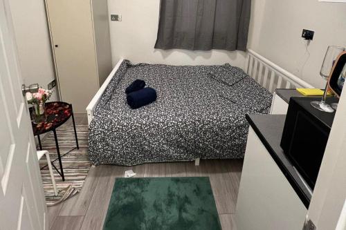 a bedroom with a bed with a blue pillow on it at Studio Sleeps 2 next to Acton Central in London