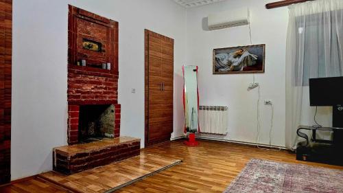a living room with a brick fireplace and a door at old Gomi iin in Tbilisi City