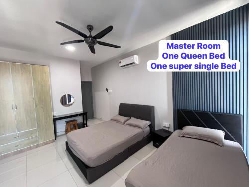 a bedroom with two beds and a ceiling fan at LC Paragon Apartment in Labuan