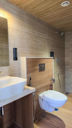 a bathroom with a white sink and a toilet at Hotel Amigos in Bangalore