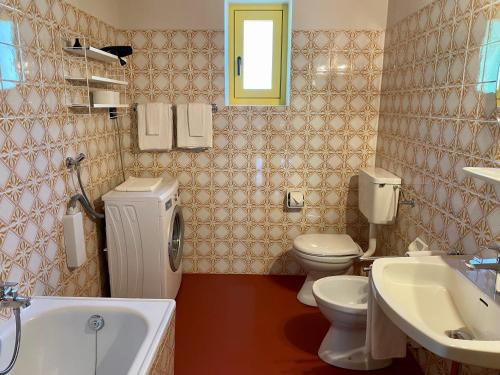 un bagno con due WC, un lavandino e una vasca di MiraOdle Apartments a Villnoss