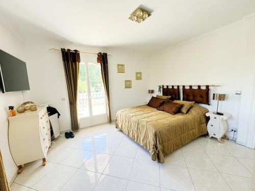 een slaapkamer met een groot bed en een raam bij Luxury villa spa, sauna, billiards table in Montauroux