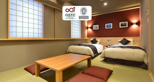 a hotel room with two beds and a table at Best Western Plus Hotel Fino Chitose in Chitose