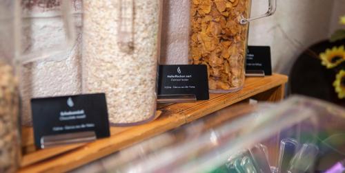 three jars of food sitting on a wooden shelf at Hotel Perlach Allee by Blattl in Munich