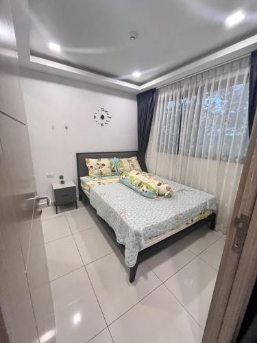 a bedroom with a bed and a window at Arcadia Beach Continental By Palmera Pattaya in Pattaya South