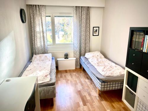 a room with two beds and a window at Cosy Station Homestay in Rovaniemi