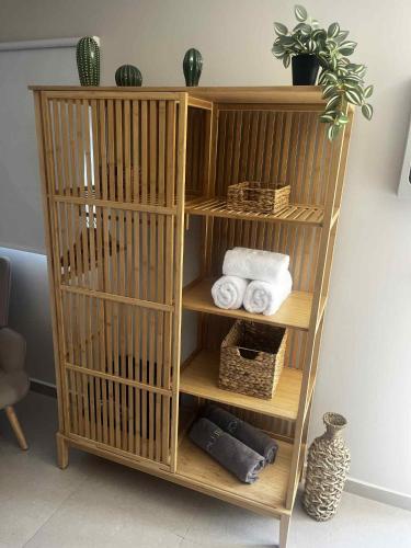 a wooden book shelf with towels and a plant at Exclusive Del Mare Hotel in Sidari