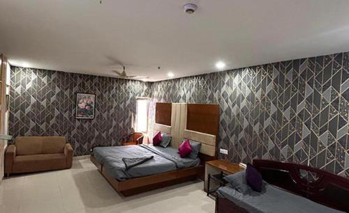 a bedroom with a bed and a couch at FabHotel Ayaansh in Hyderabad