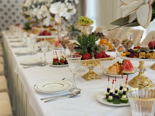 een lange tafel met hapjes en borden met eten bij Khorazm Hotel in New Uzbekistan Park in Teshabayguzar