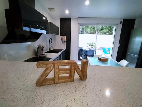 a wooden sign on the counter of a kitchen at Villa détente - Entre terre et mer in Le Gué-dʼAlléré