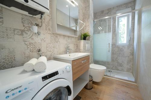 a washing machine in a bathroom with a sink and a toilet at Apartments Break with pool in Novalja