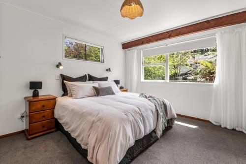 a bedroom with a large bed and a window at Tranquil Hideaway - Lake Okareka Holiday Home in Lake Tarawera