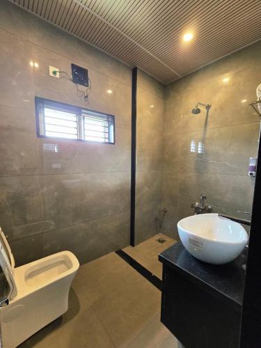 a bathroom with a sink and a toilet at SDK Residency in Shravanabelagola