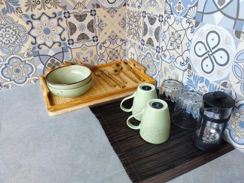 een dienblad met een kom en kopjes op een tafel bij One bed room - 5 minutes to beach and cafe in Denpasar