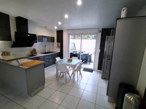 a kitchen with a table and chairs in a room at Villa détente - Entre terre et mer in Le Gué-dʼAlléré