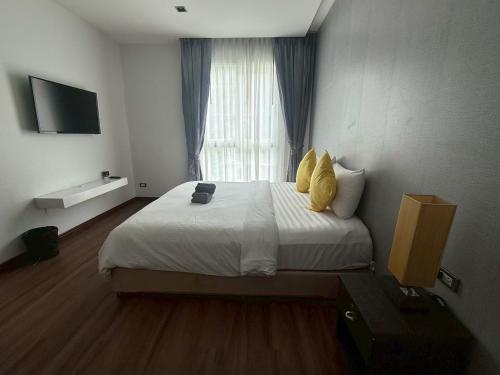 a bedroom with a large bed with a window at Emerald Terrace Resort 622 in Patong Beach