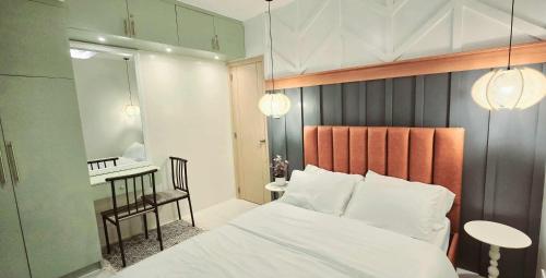 ein Schlafzimmer mit einem Bett, einem Tisch und einem Stuhl in der Unterkunft 2BR Penthouse SMDC Wind Residences Tagaytay in Kaybagal
