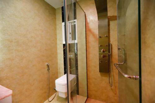 a bathroom with a toilet and a glass shower at Qinwan Hotel & Suites in Rawalpindi