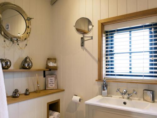 a bathroom with a sink and a mirror at Lillie's Shepherds Hut at Shepherds Lodge Retreat and Wellness in Nottingham