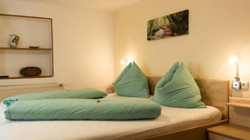 ein Bett mit blauen Kissen darauf in der Unterkunft Peterlhaus in Kleinarl