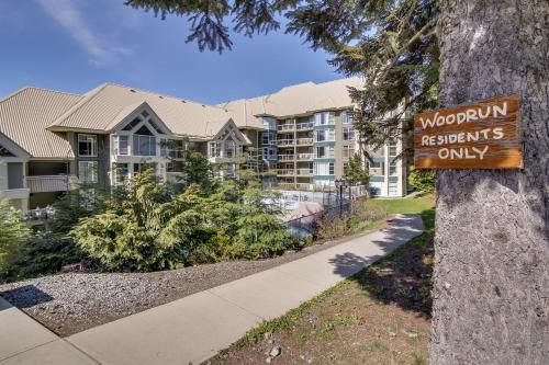 a sign on a tree in front of a apartment building at The Woodrun Lodge by Whiski Jack in Whistler