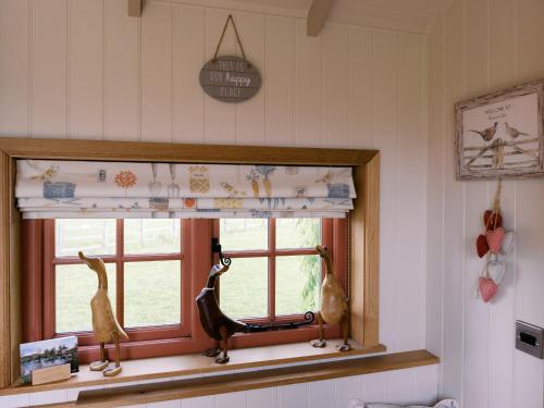 a window with two birds on a window sill at Bonnie's Shepherds Hut at Shepherds Lodge Retreat and Wellness in Nottingham