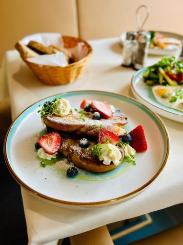 a plate of food with fruit on a table at LONDON Boutique hotel & Restaurant in Trnava