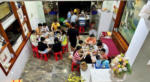 a group of people sitting at tables in a restaurant at Queen Motel Vung Tau in Vung Tau