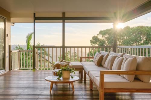 a living room with a couch on a balcony at Oak Ridge Cottage in Maleny
