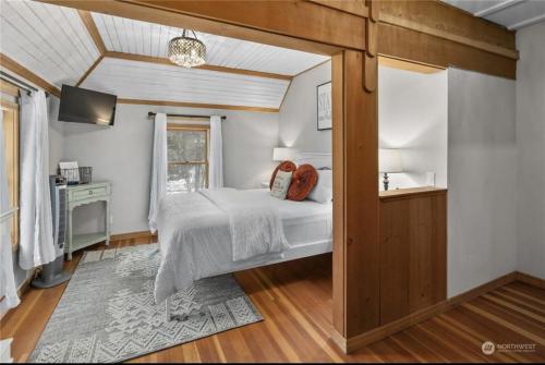 a bedroom with a bed and a desk and a window at Huckleberry House in Roslyn