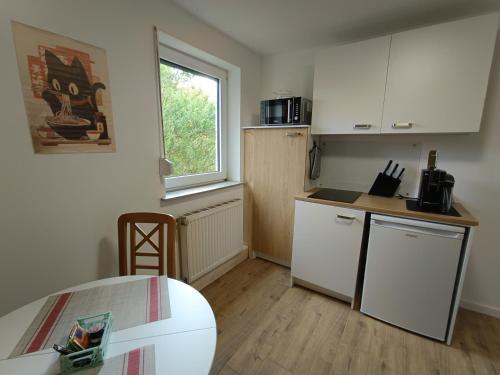 a small kitchen with white cabinets and a window at Cozy apartment in Harsum near Hildesheim in Harsum