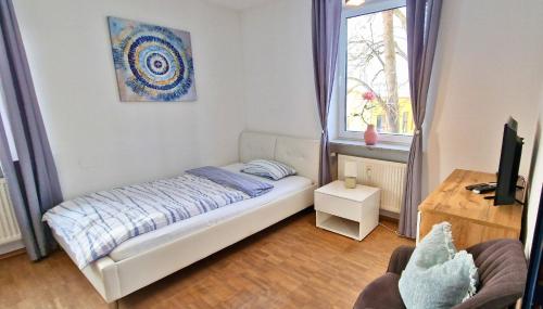 a small bedroom with a bed and a window at Bahnhof City Loft & Apartments in Augsburg