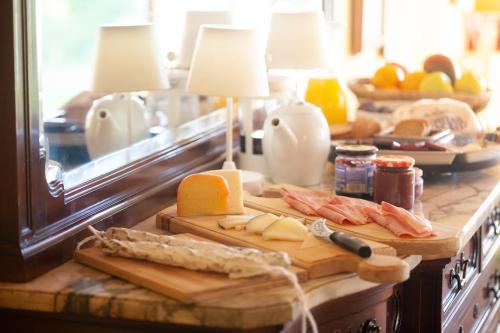 CrespiáにあるCan Sisó, Alojamiento por habitacionesのまな板の上にチーズと肉が置かれたキッチンカウンター