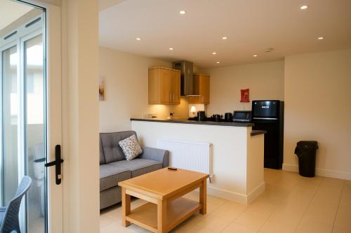 Una sala de estar con un sofá y una cocina. en West Beach - Holiday Apartments, en Westward Ho