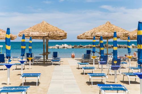 a beach with chairs and umbrellas and the ocean at Hotel Mara in Ortona